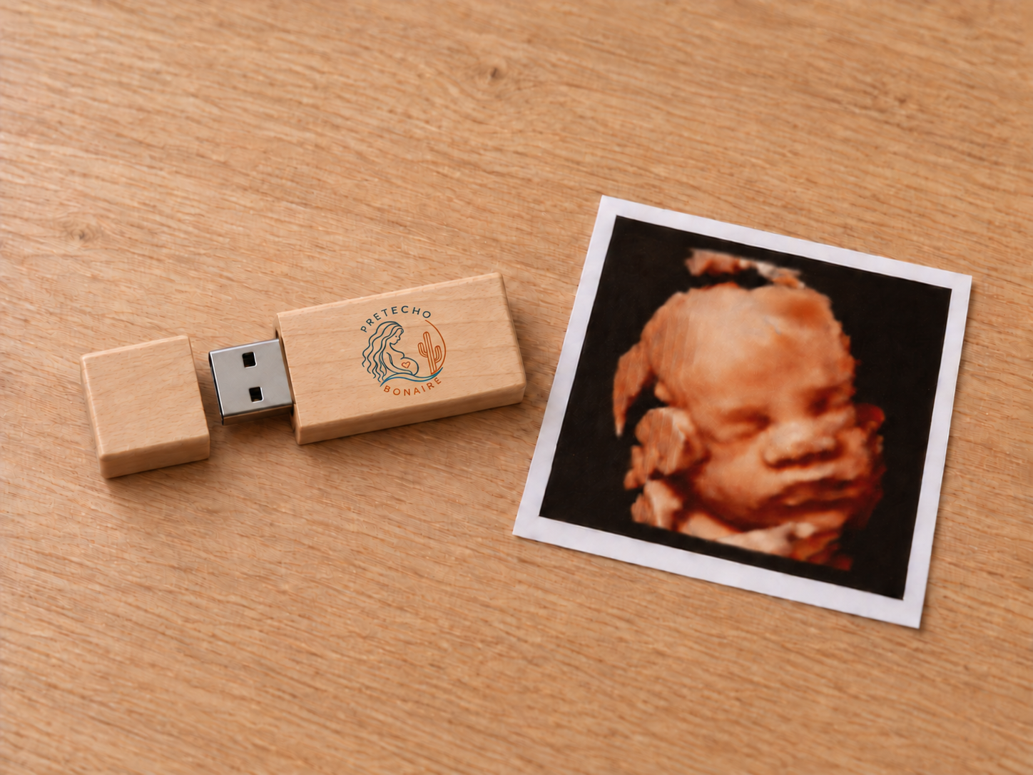 Een 3D-echofoto en houten USB-stick met Pretecho Bonaire-logo op tafel
